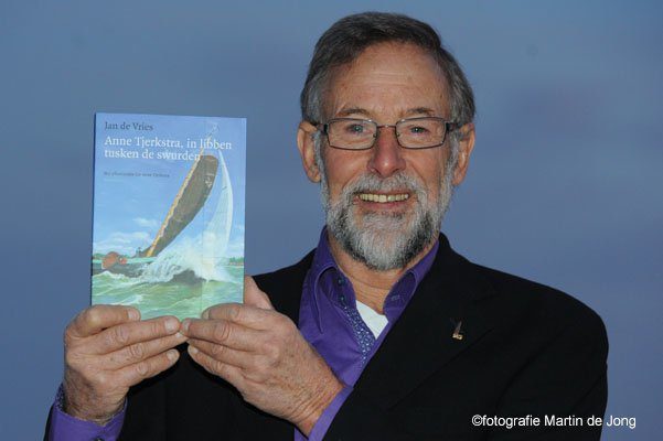 Anne Tjerkstra toont het boek waarin z'n levensverhaal staat beschreven