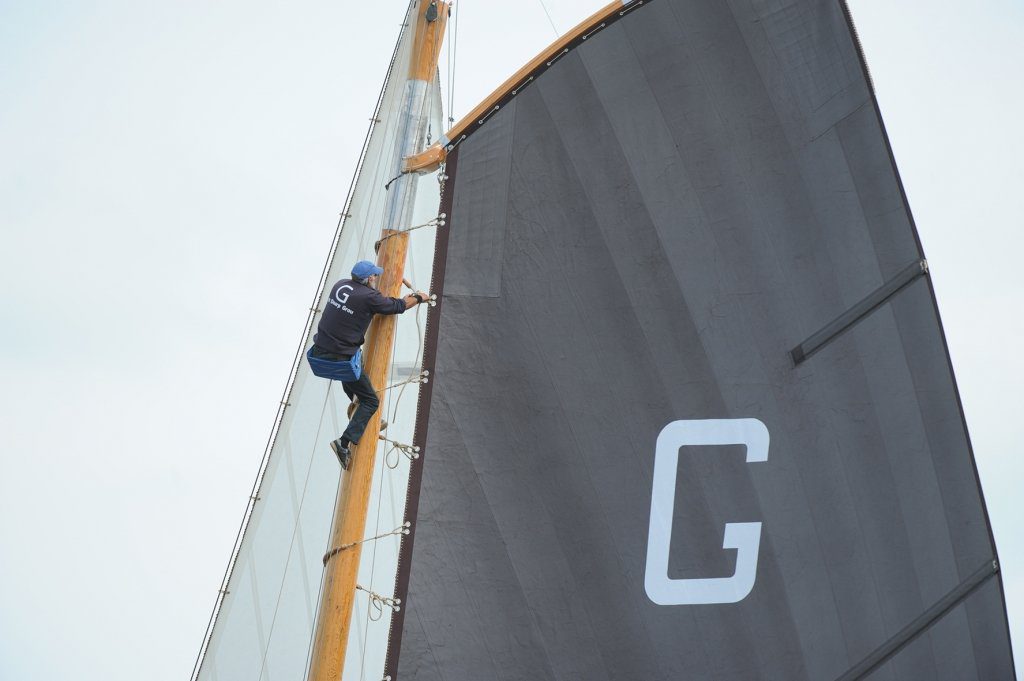 Anne Tjerkstra hoog in de mast van het Grouster skûtsje om de rabanden te verstellen