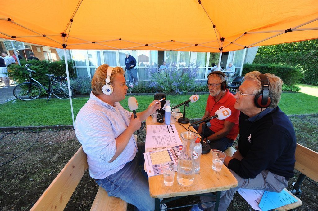 Presentator Floris Prenger met gasten Anne Tjerkstra en CdK John Jorritsma aan tafel