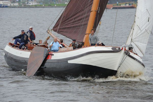 Pake Eildert Meeter aan het helmhout en kleinzoon Eildert op het voordek van het Huzumer skûtsje