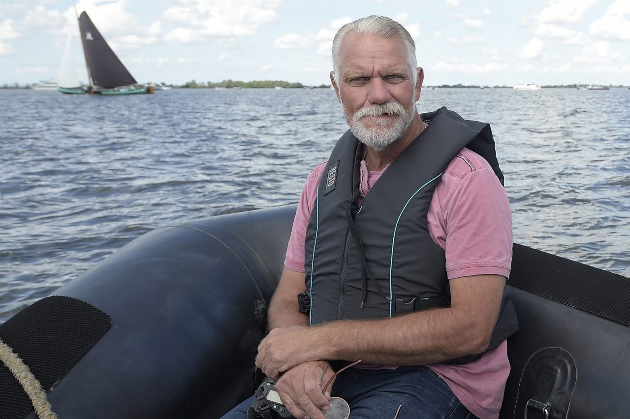 Fotograaf Sietse de Boer zittend voor in de punt van de persboot in 2018